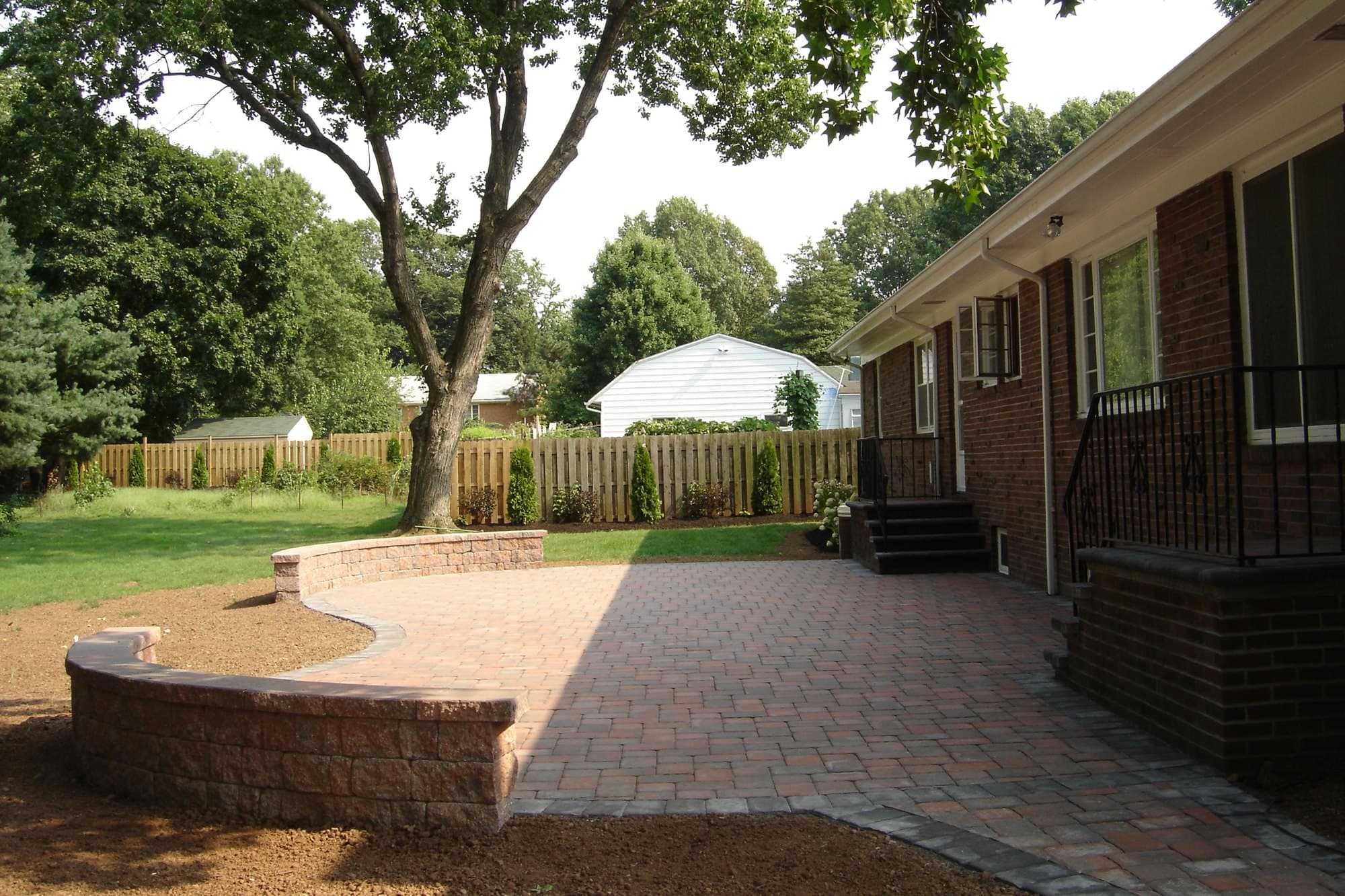 Brick paver patio with sitting walls in a backyard