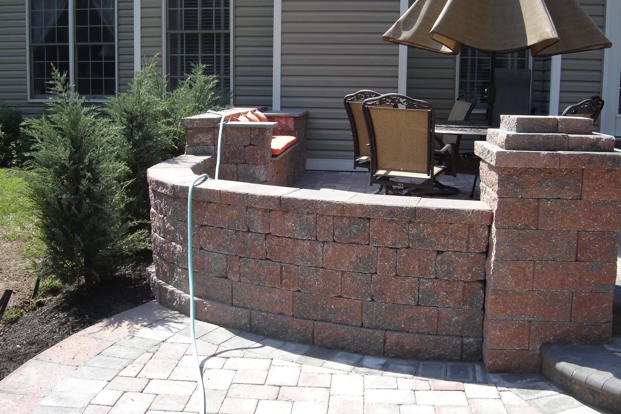 Curved stone seat wall and patio dining area